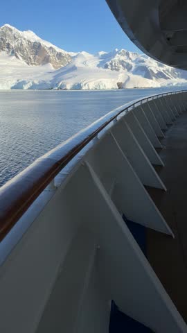 Antarctica Cruise Ship Point of View Pan From Deck to Beautiful Mountain Range of Snow and Glaciers on Sunny Day. Adventure Travel (Vertical Video)