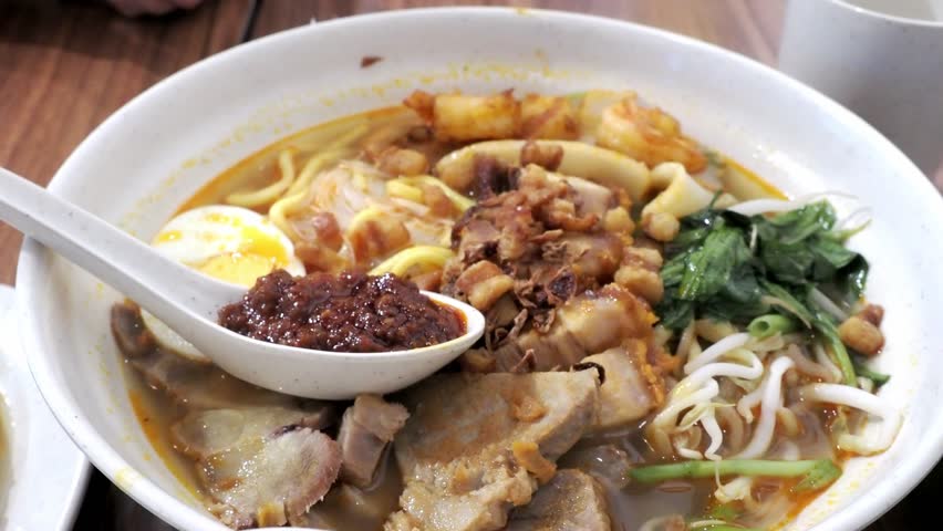 Bowl of Hokkien Har Mee (Prawn Noodles), a rich, umami-packed Malaysian and Singaporean noodle soup dish. Mix of egg noodles, rice vermicelli, with prawns, sliced pork, bean sprouts, and boiled egg.