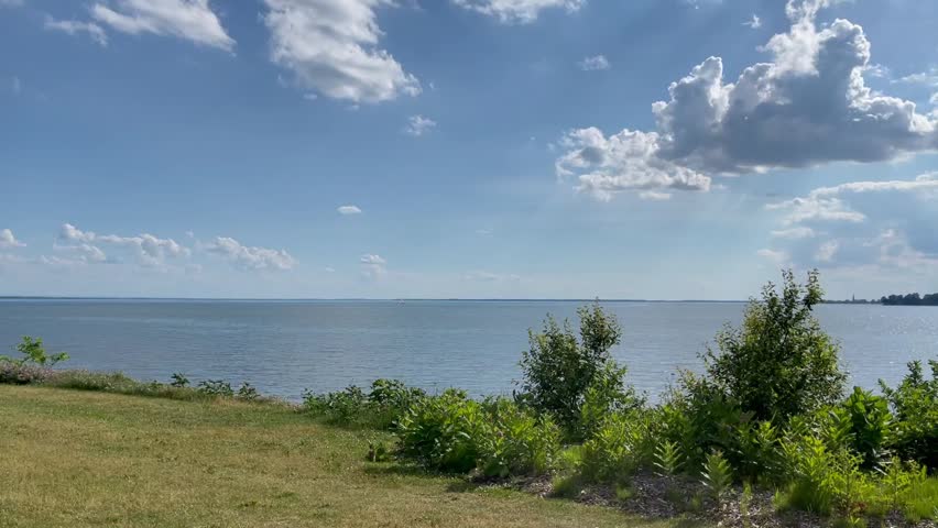 Peaceful Lake View with Blue Sky, White Clouds and Gentle Summer Waters