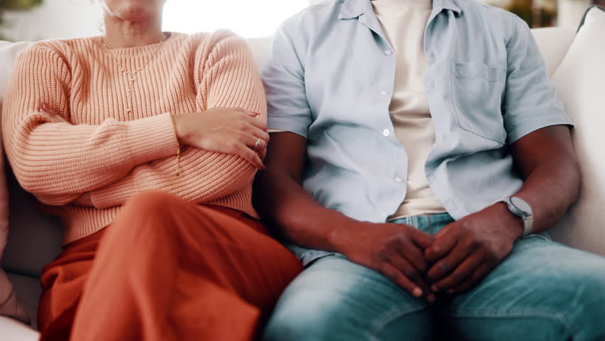 Divorce, sofa and couple with crossed arms for fight, conflict and tension for argument in home. Hands, marriage and man with woman with disagreement, frustrated and upset for relationship issue