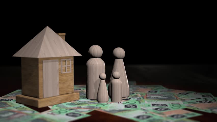 Rotating shot of wooden family figures and a house model on one hundred australian dollar banknotes.