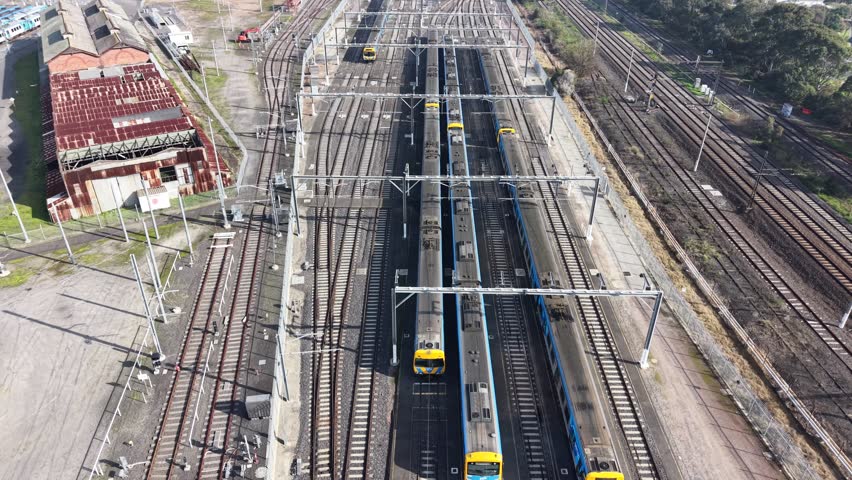 Commuter trains maneuvering through a complex network of tracks at a large railway junction