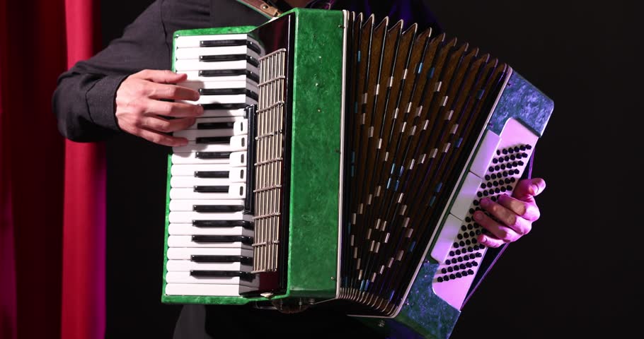 Man playing piano accordion on stage, closeup