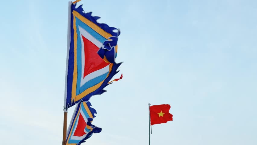 Traditional Vietnamese Festive Pennant and National Flag waving in the strong wind with blue sky in the background
