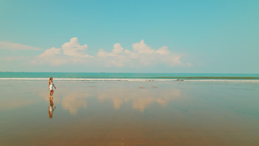 Female traveler walking along tropical shoreline sandy beach in Costa Rica