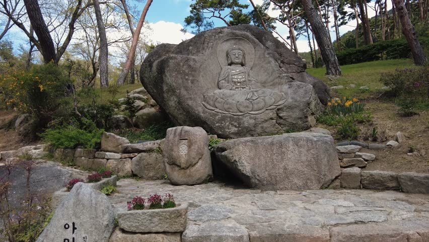 Ancient Buddha Statue Carved into a Large Stone Rock in a Peaceful Garden