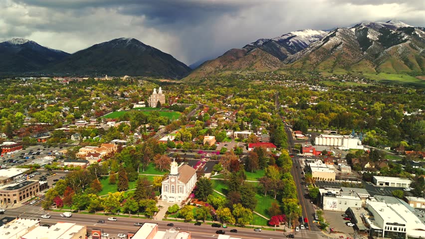 Aerial view of a mountain valley town with storm clouds and snow capped peaks