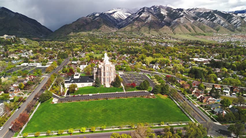 Orbiting drone shot circling a hilltop landmark surrounded by green lawns