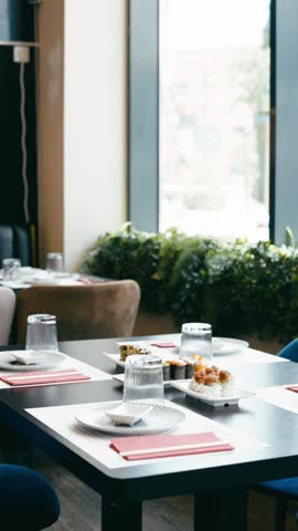 Modern restaurant interior with an elegantly set table featuring various sushi rolls and dishes. Perfect setting for a lunch or dinner date. Vertical