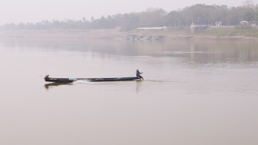 Fisherman setting nets on the Mekong river in Laos