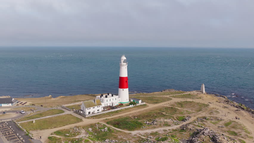 Aerial drone view of Portland Bill Lighthouse standing on the rugged coastline of the Isle of Portland, Dorset, England, overlooking the English Channel
