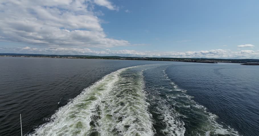 Ferry wake creates striking textures across calm water during departure from Matane.