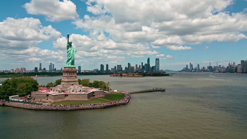 Statue of Liberty iconic American symbol. Statue of Liberty in New York. Financial district sees Statue of Liberty. Skyline panorama shows Statue of Liberty.