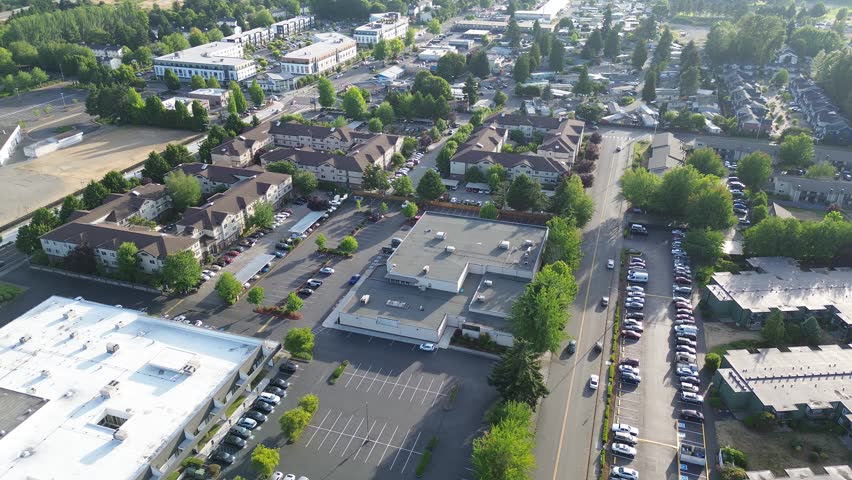 Suburban infrastructure layout apartment complexes sit near dense storage unit facilities in Kent. Tree lined streets and organized parking grids define the residential and commercial mix, WA. USA
