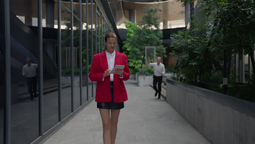 Woman man couple hug kiss urban office building glass walkway, businesswoman using tablet smartphone in modern corporate courtyard with greenery, affectionate colleagues near reflective wall