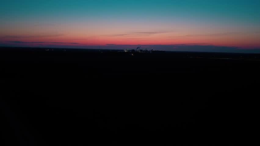 Twilight lit agri-processing complex on open plains in North Dakota. B-roll for food supply chain, ag manufacturing, and rural-employer marketing showing round-the-clock output.