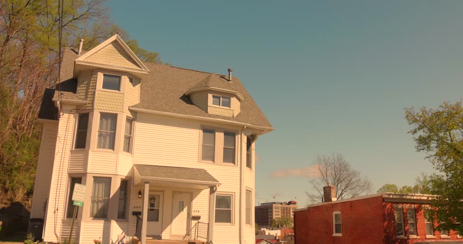 Large white house with front steps on a sunny day in a residential Dubuque neighborhood