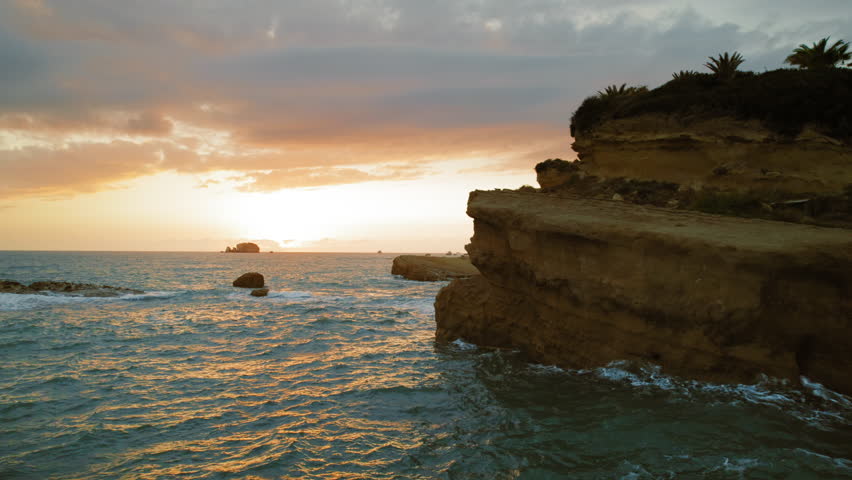 Sunset view over ocean and rocky cliffs on Kefalonia coast in summer Greece