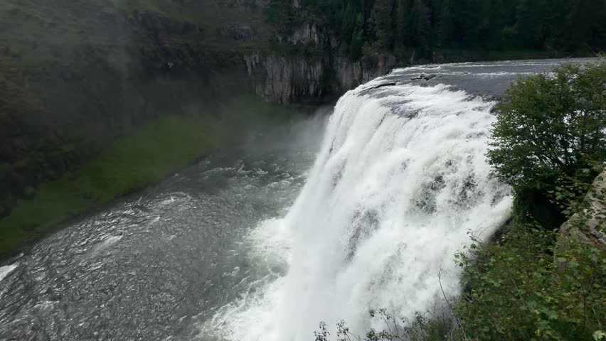 Upper Mesa Falls in Idaho with a wide waterfall dropping into a misty forested canyon.