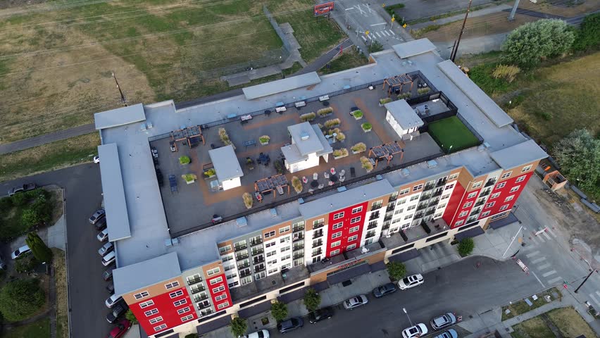 Elevated terrace gardens utilize synthetic turf and native vegetation atop apartment buildings near downtown Kent. Sustainable planning integrates recreational areas within urban settings in WA. USA