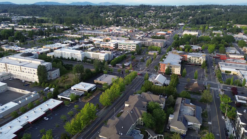 Low rise professional buildings anchor historic business zones near downtown Kent, King County. Dense mixed use development signals ongoing neighborhood transformation occurring throughout WA. USA