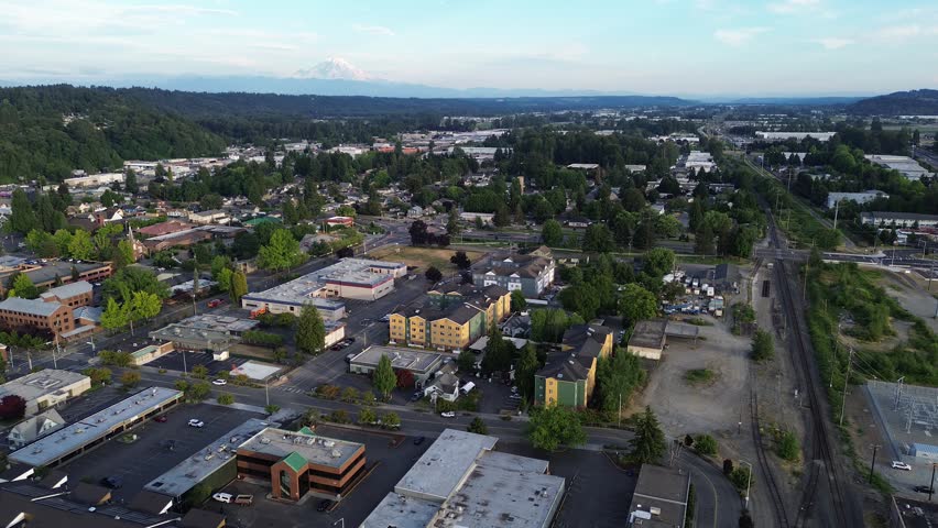 Active rail lines and arterial streets intersect near historic downtown Kent, Mt. Rainier background. Multi modal connectivity underpins economic development for urban hubs found throughout WA. USA
