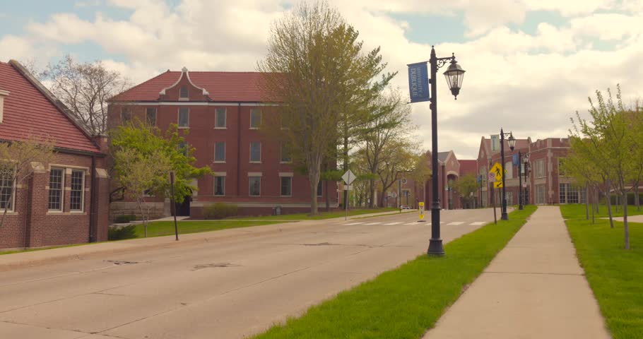 Quiet street view of Midwest university campus with brick buildings and spring trees