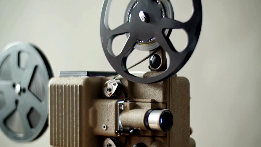 Vintage film projector in action as film rolls through reels, evoking memories of classic cinema and the art of filmmaking in a nostalgic setting.