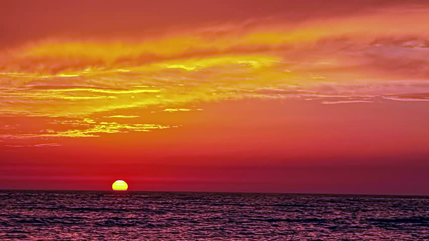 Stunning Vibrant Sunset Over Ocean with Dramatic Orange and Red Clouds at Dusk