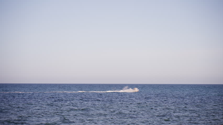 Jet ski rider enjoying scenic ride across calm sea near coastline. Luxury vacation, coastal tourism, outdoor recreation and unforgettable summer travel experience.