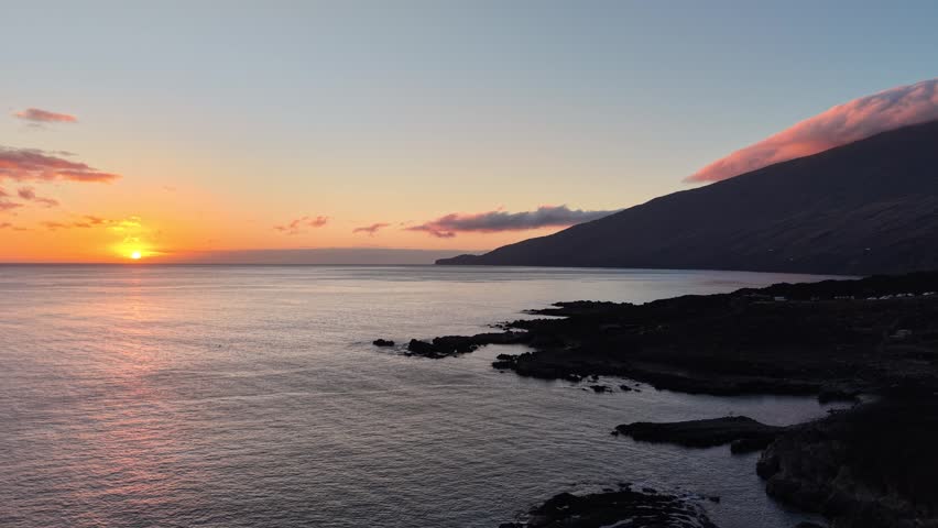 Aerial view of a scenic coastal landscape with mountain cap cloud during sunset
