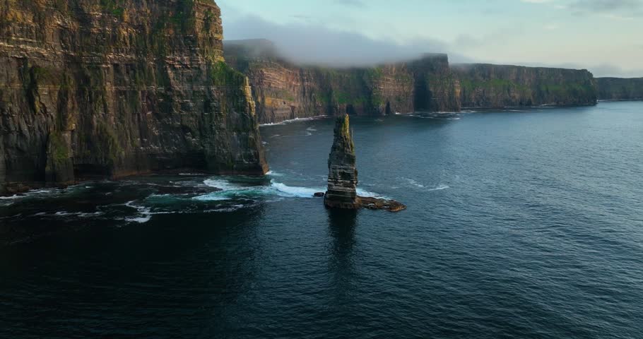 Aerial drone flyby of sea stack at Cliffs of Moher along Atlantic coastline, Ireland