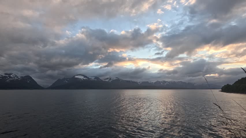 Cloudy Norwegian fjord landscape during polar day, timelapse
