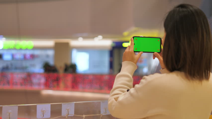 Asian women from East Asia, including China, use their mobile phones to communicate in a shopping mall.