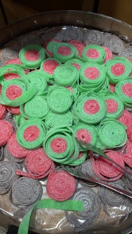 Bright colorful gummy candies displayed in retail setting. Chewy sweets made with agar, gelatin are arranged in attractive assortment. Confectionery presentation, vivid colors, and appealing textures.