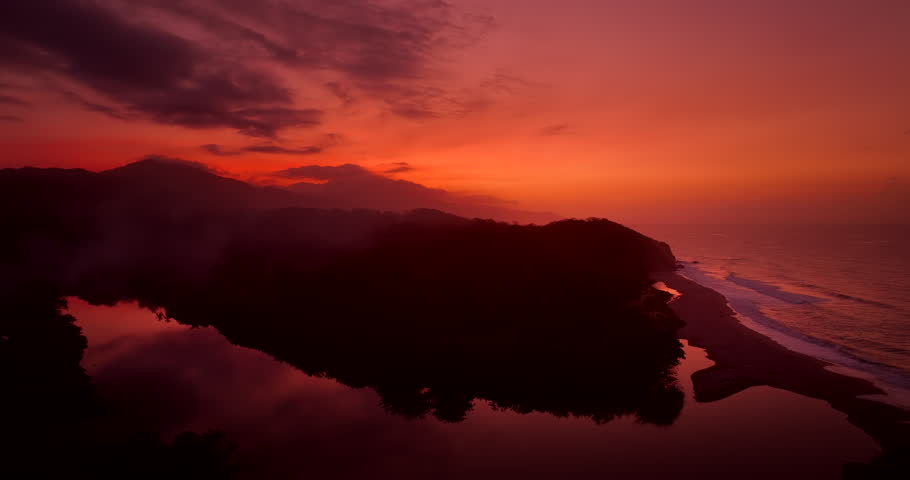 Vibrant warm sunset hues over Tayrona National Park river and coastline. Aerial