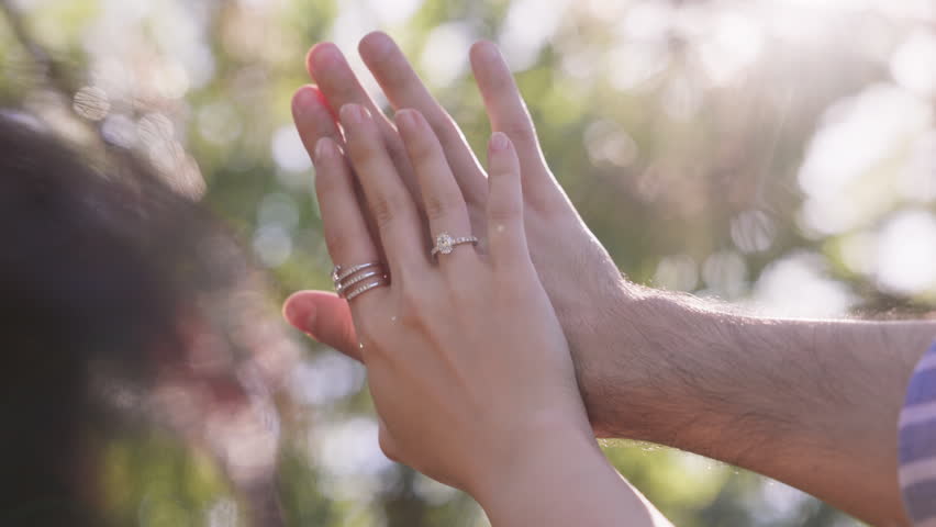 Close-up of a couple admiring an engagement ring on a woman