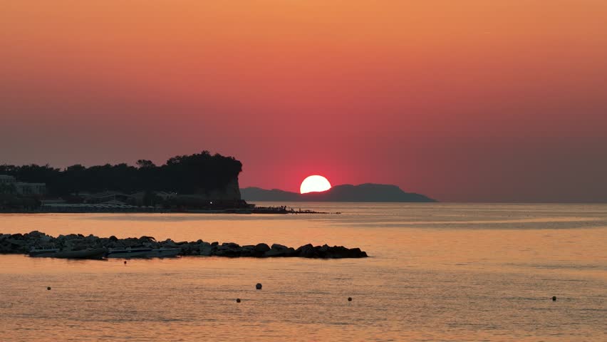Beautiful Red Sunset over the Ionian Sea with Silhouette Cliff and Distant Islands, Roda Beach, North Corfu, Greek Island, Greece - 4K Video Shot