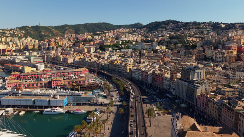 Aerial view over busy harborfront road, marina, and cityscape in Genoa, Italy