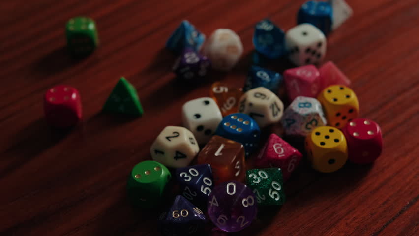 A vibrant collection of polyhedral dice, including various D4, D6, D8, D10, D12, and D20 types, lies scattered on a warm wooden table. Perfect for illustrating themes of tabletop gaming, chance, and role-playing adventures.