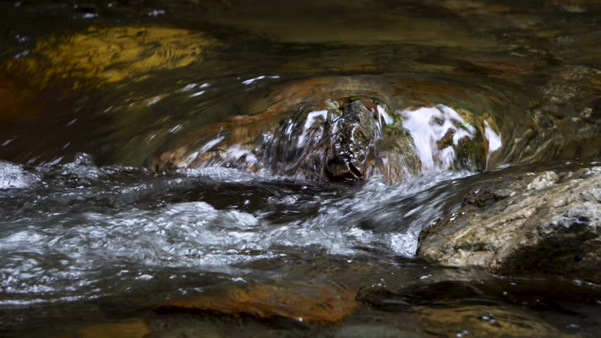 The flow of a mountain stream winding through the rocks