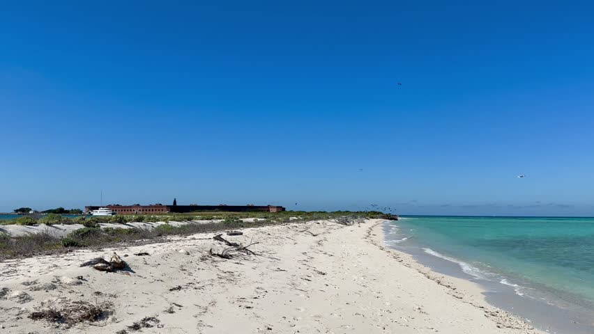 Panoramic, scenic view of Garden Key island and Fort Jefferson. Historical masonry brick fortress surrounded by water. Sea plane arrives at the island. Birds are flying around.  Dry Tortugas National Park, Florida 