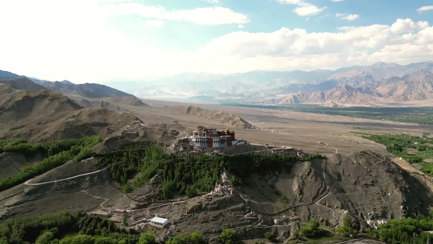 Aerial view of Matho Gompa monastery perched on a rocky hill surrounded by arid mountains and green trees in the Indus Valley, Matho, Ladakh, India.