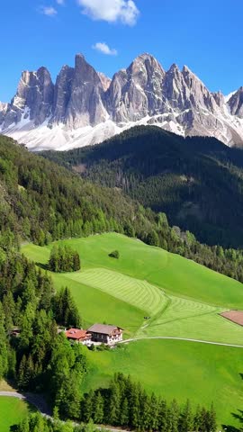 Vertical aerial drone view of Santa Maddalena (Magdalena) village with the Dolomite mountains in the background. Val di Funes valley, Trentino-Alto Adige region. Italy, Europe.