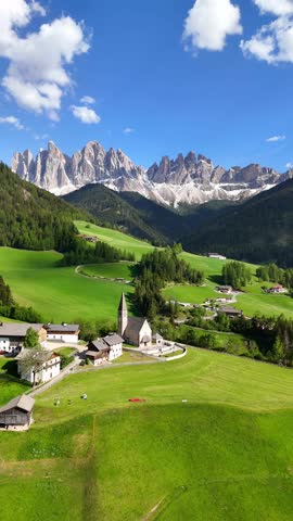 Vertical aerial drone view of Santa Maddalena (Magdalena) village with the Dolomite mountains in the background. Val di Funes valley, Trentino-Alto Adige region. Italy, Europe.