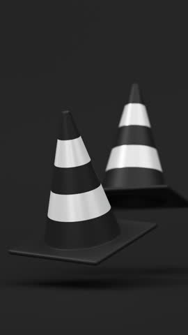 Front view pair of floating traffic cones in white and black on a black background for road safety and construction warning. Vertical video.