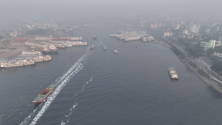 Aerial view of Buriganga River with numerous passenger ships and cargo vessels navigating the waterway in Dhaka Division, Bangladesh.