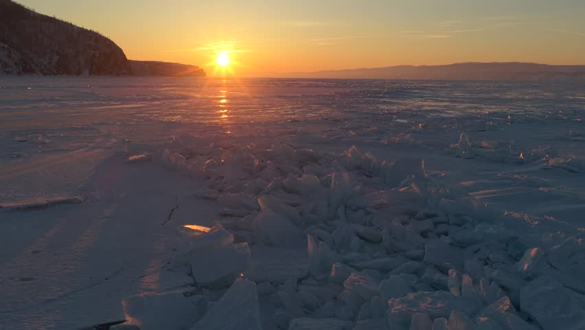 Aerial view of Lake Baikal at sunset with ice chunks on the frozen surface in Khuzhir, Irkutsk Oblast, Russia.