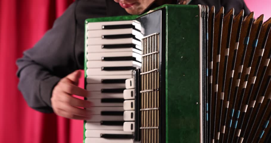 Man playing piano accordion on stage, closeup