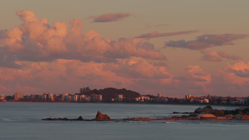 Aerial view of Currumbin Alley at sunset with golden light on the coastline and city skyline in City of Gold Coast, Queensland, Australia.